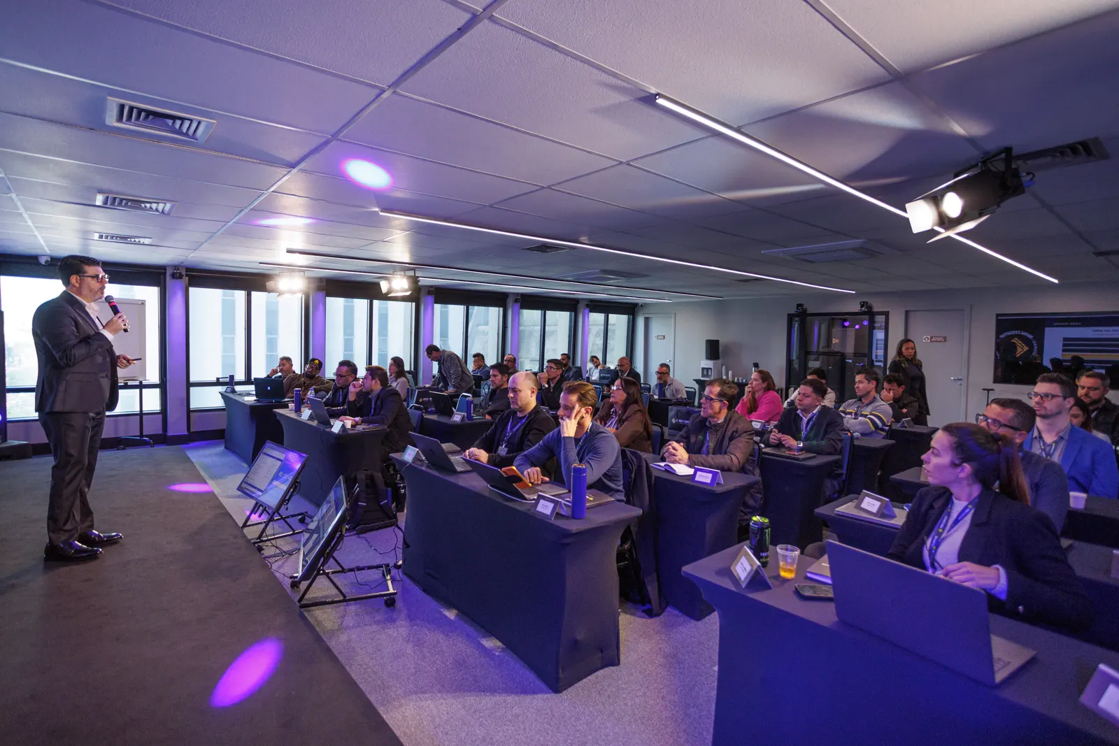 Sala cheia de empresários com notebooks abertos num treinamento presencial da Brave